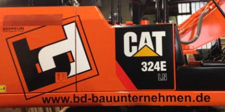 Folierung eines Baggers mit Schriftzug der Baufirma durch Folien Fischer
